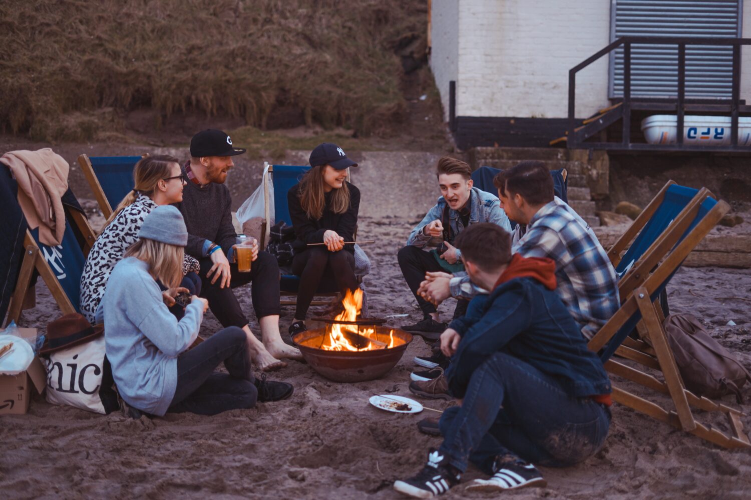 Friends talking in a circle around a campfire.